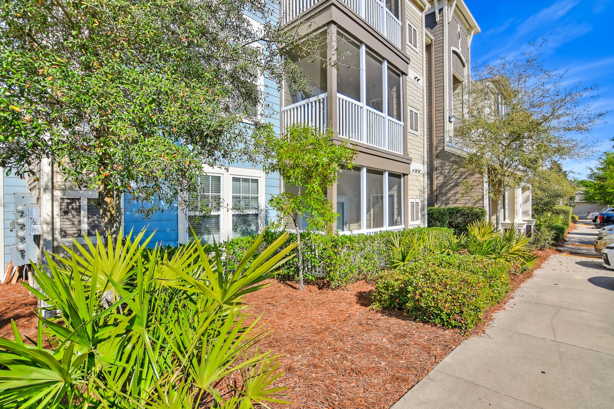 A building with a balcony and a tree in front of it.